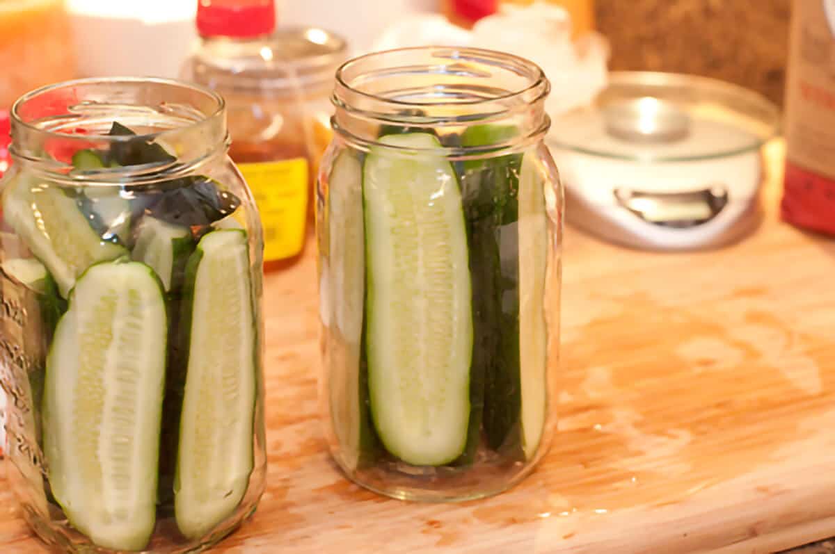 Cucumbers packed into glass jars.