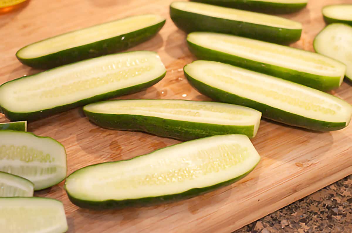 Cucumbers cut in half on a cutting board.