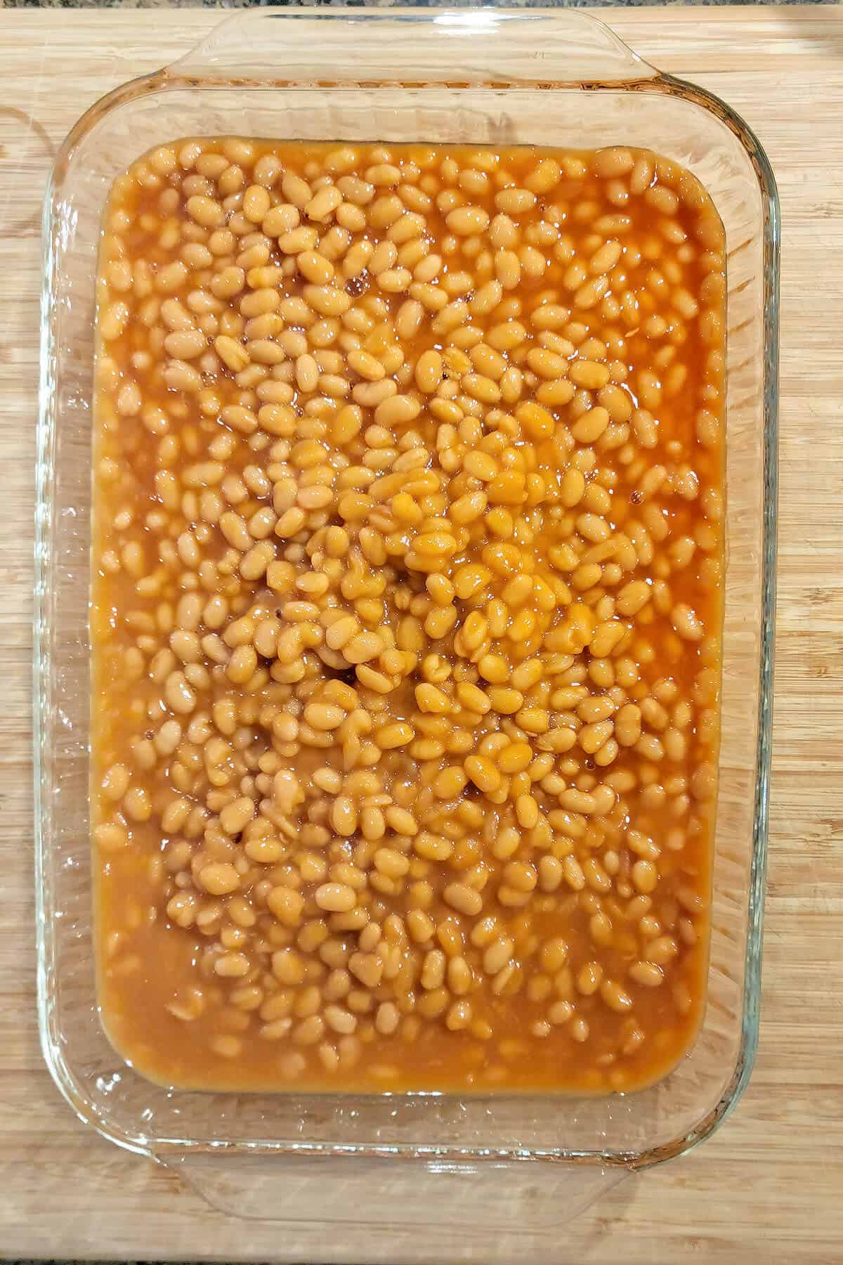 Lightly drained pork and beans in a casserole dish.