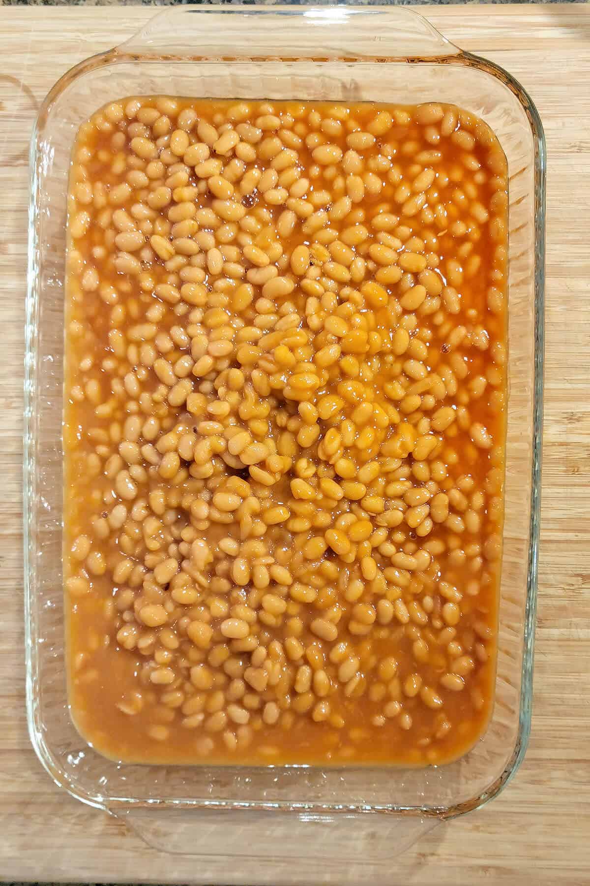 Lightly drained pork and beans in a casserole dish.
