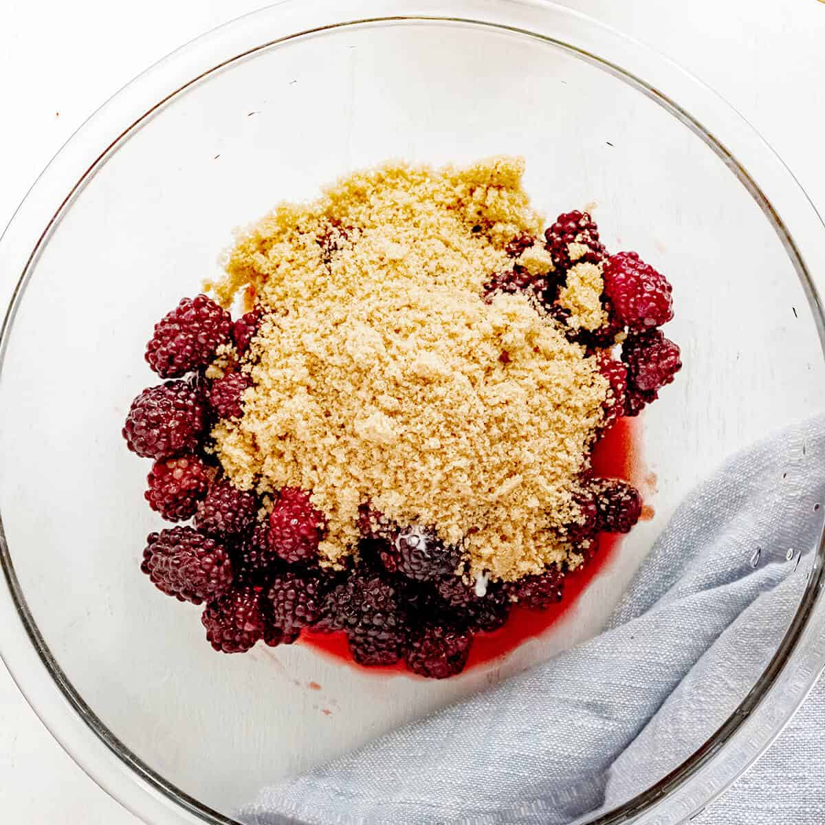 Blackberries and sugar in a mixing bowl.