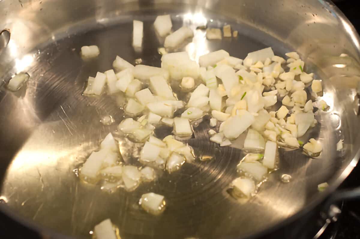 Onions and garlic cooking in a skillet.