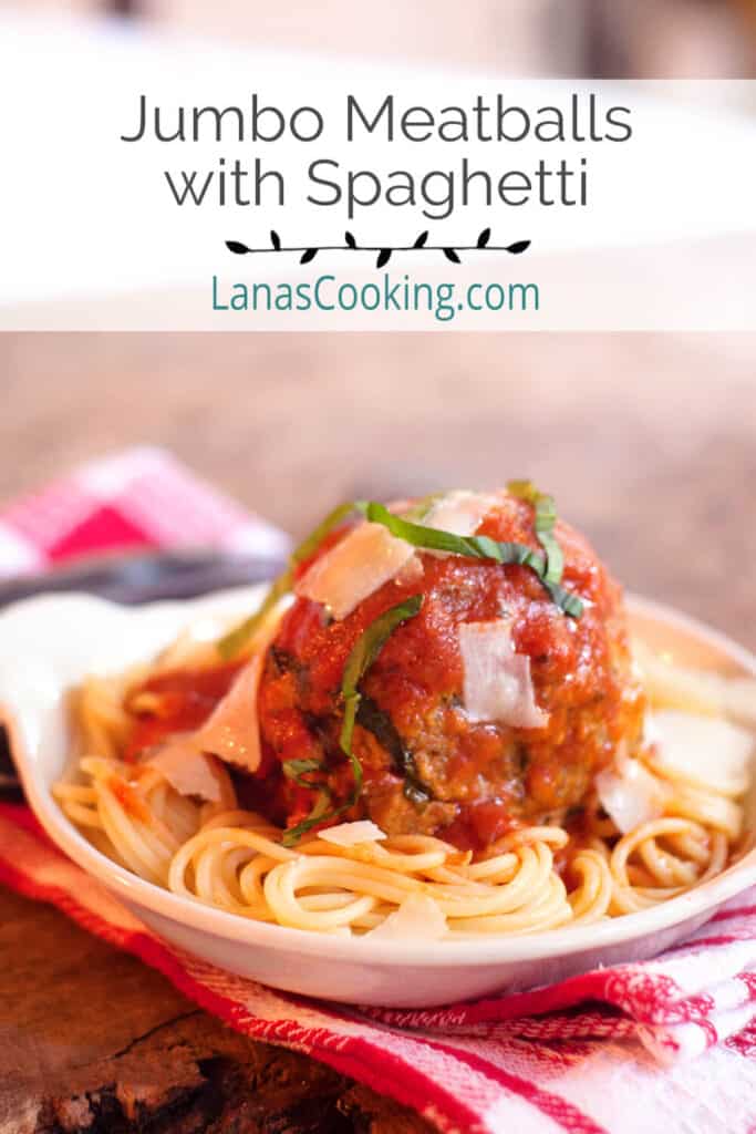 A serving of jumbo meatballs and spaghetti in a white bowl.