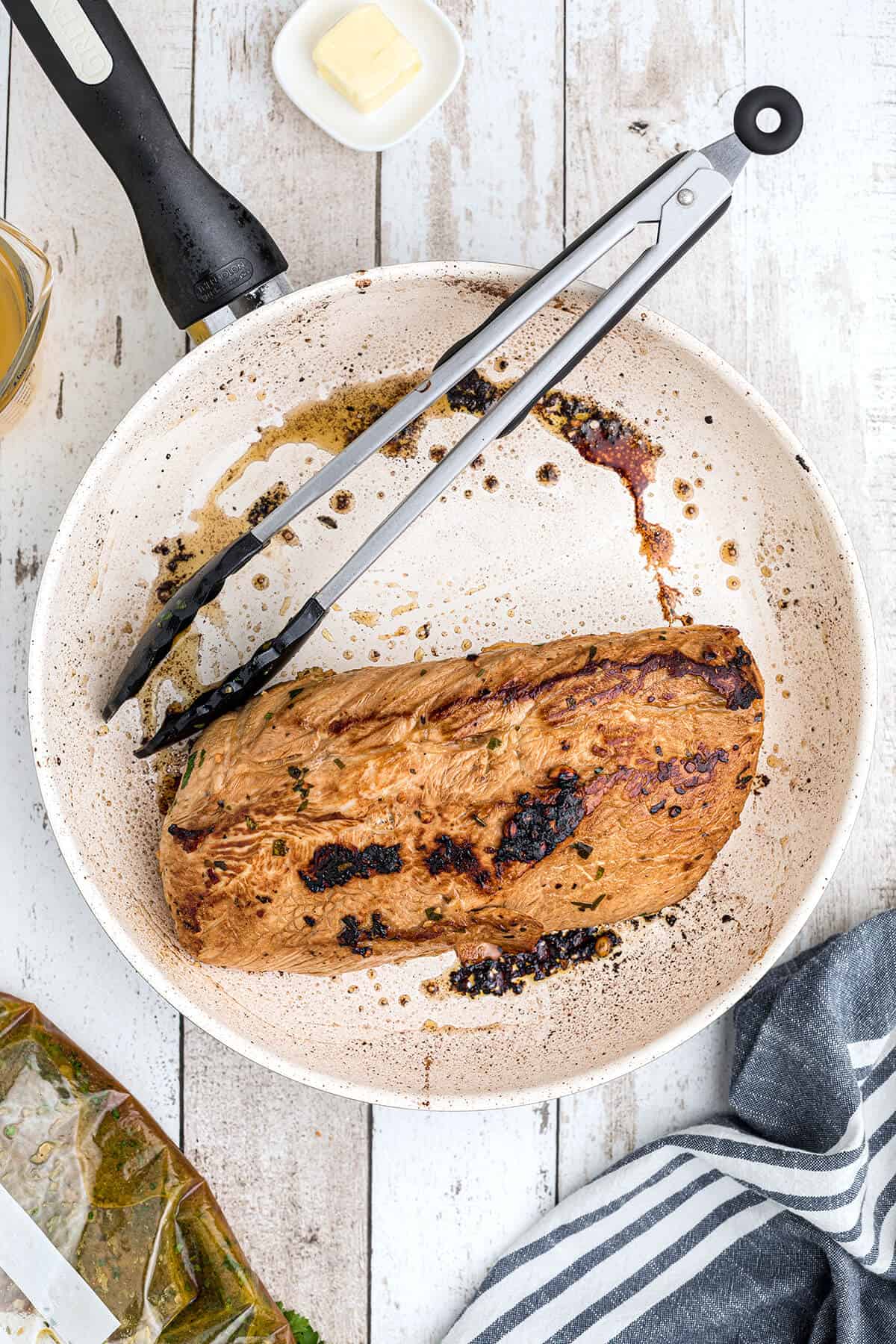 Browning the pork loin in a skillet.