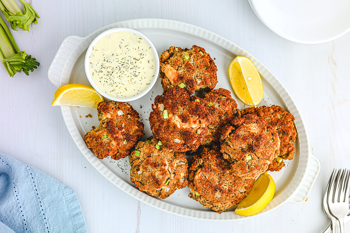 Finished salmon croquettes on a white serving platter.