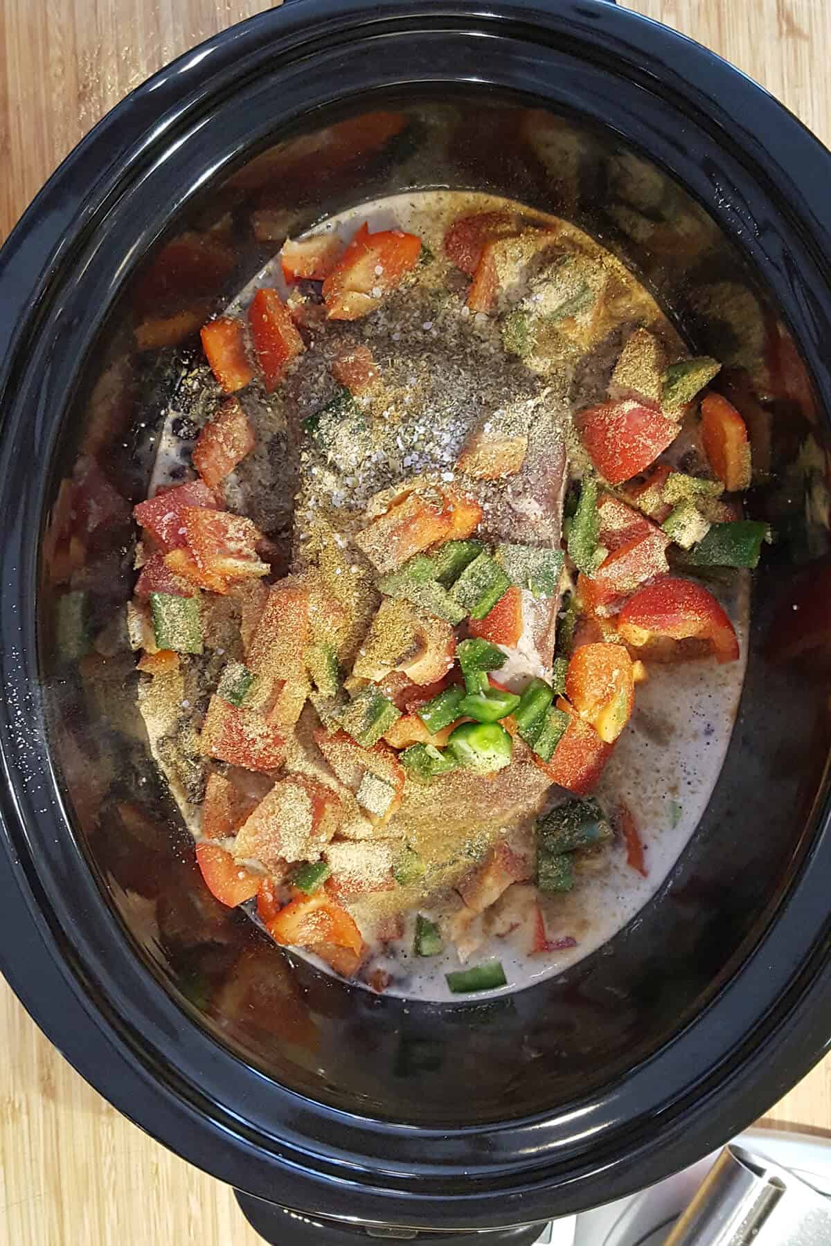 All ingredients added to a slow cooker vessel.
