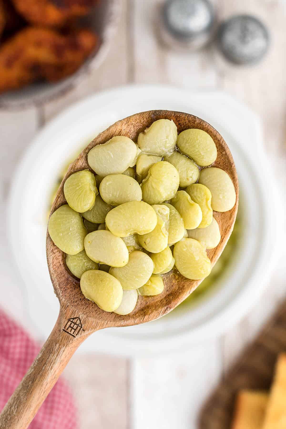 Butter beans in a wooden spoon.