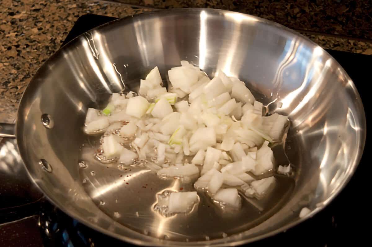 Sauteing onions and garlic in a skillet.