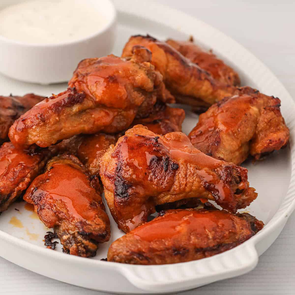 Finished buffalo wings on a serving plate.