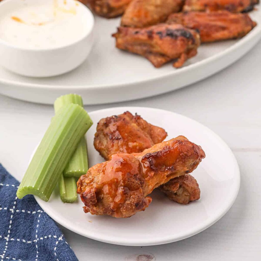 Finished buffalo wings on a serving plate.