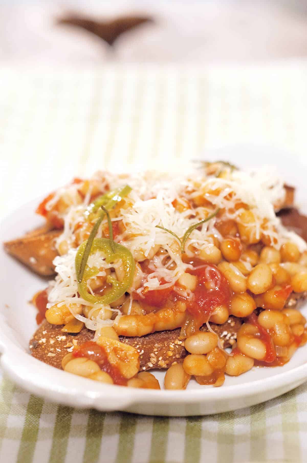 A serving of beans on toast on a white plate.