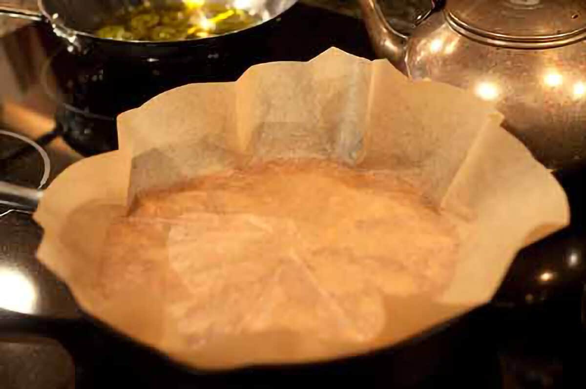 A skillet covered with parchment paper.