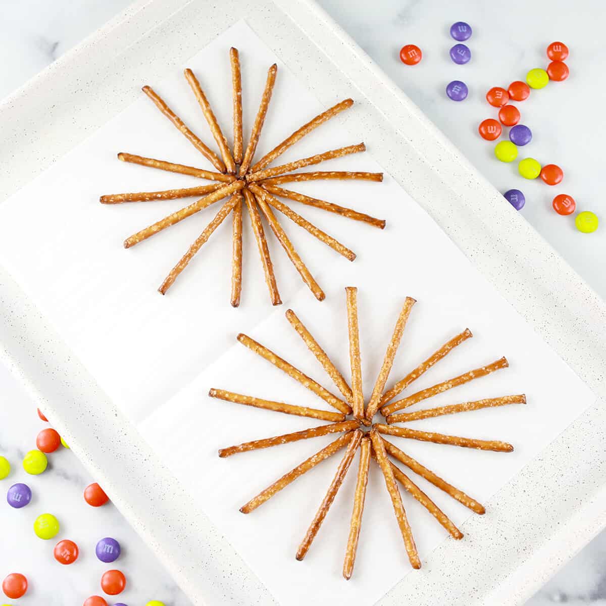 Pretzel sticks on parchment paper lined baking sheet.