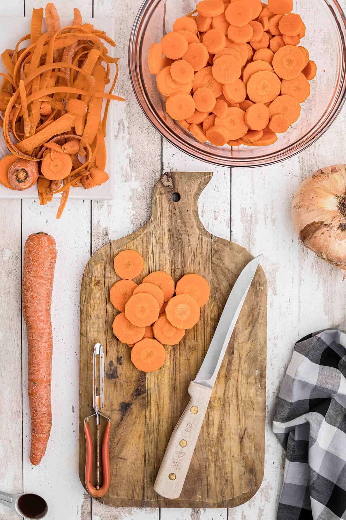 Carrots being peeled and cut into rounds.