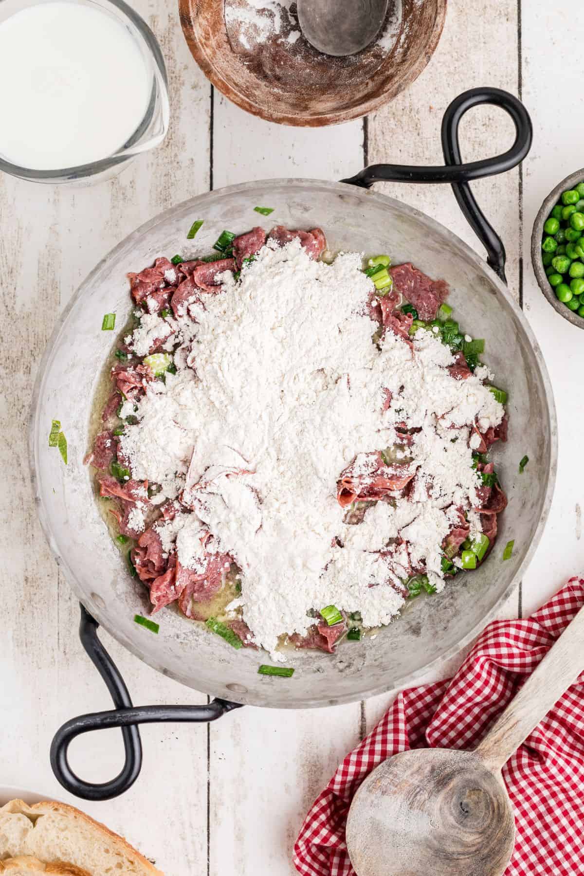 Flour sprinkled on top of the beef and green onion mixture.