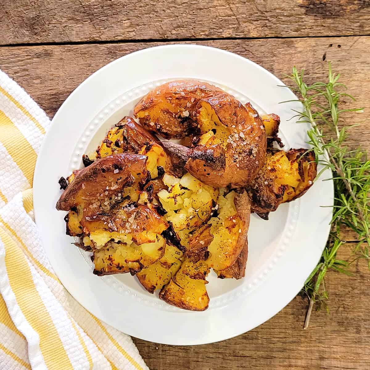 Finished smashed potatoes on a serving plate.