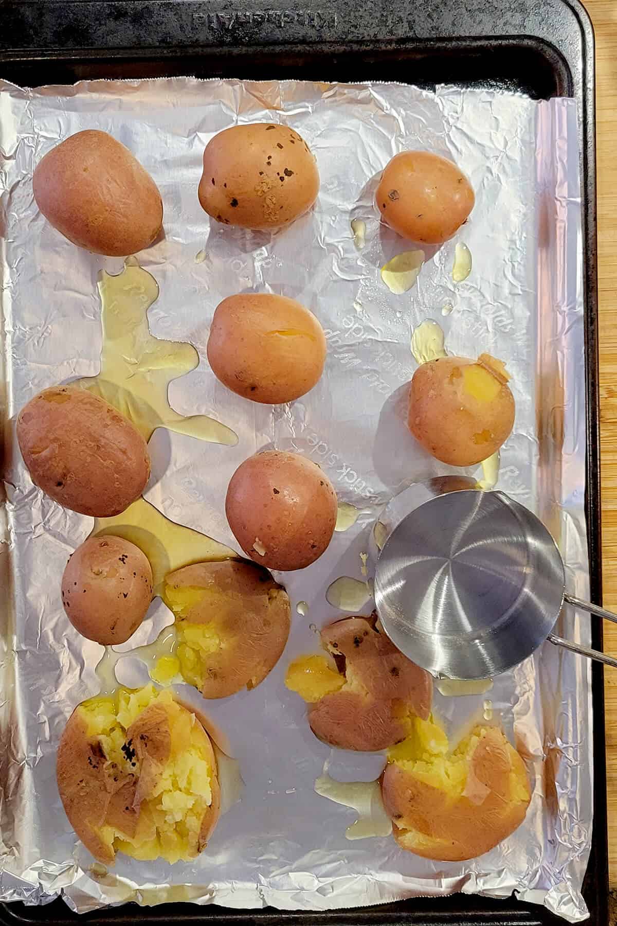 Potatoes and oil on baking sheet.