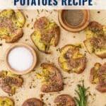 Crispy smashed potatoes on parchment with bowls of salt, pepper, and fresh rosemary; text overlay: recipe title.