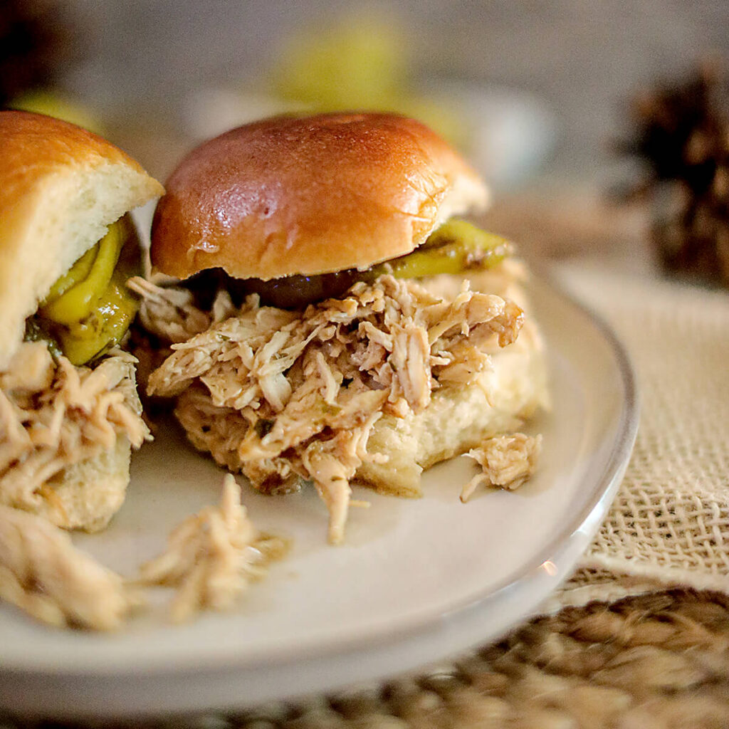 Two chicken sliders on a serving plate.
