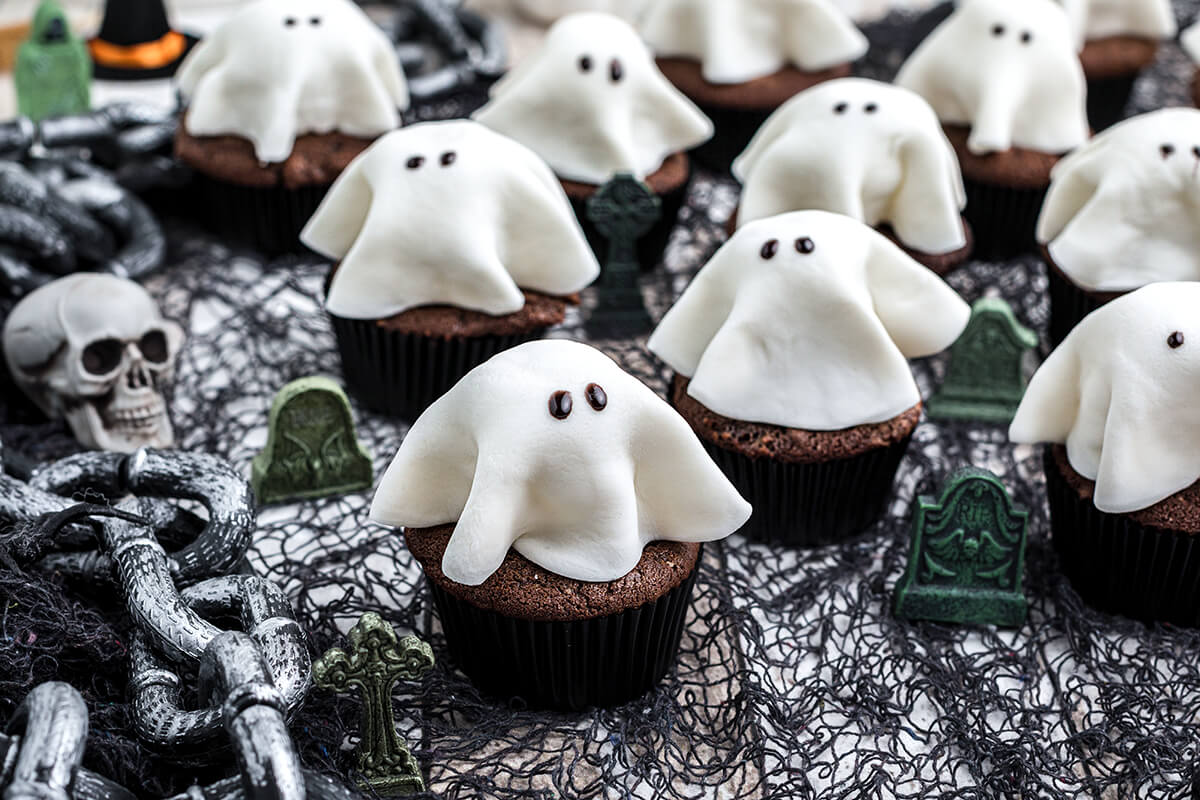 Finished Halloween ghost cupcakes on a scary background.