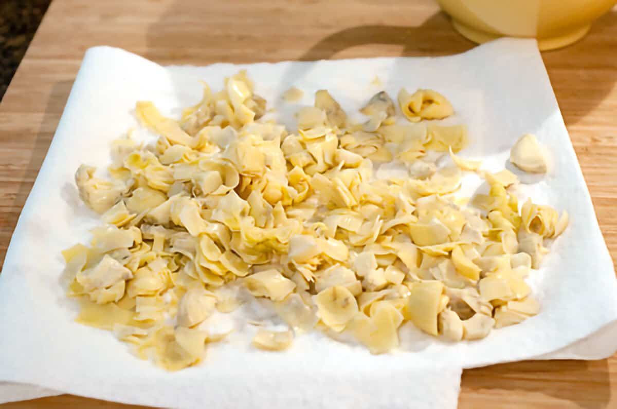 Draining chopped artichoke hearts on paper towels.