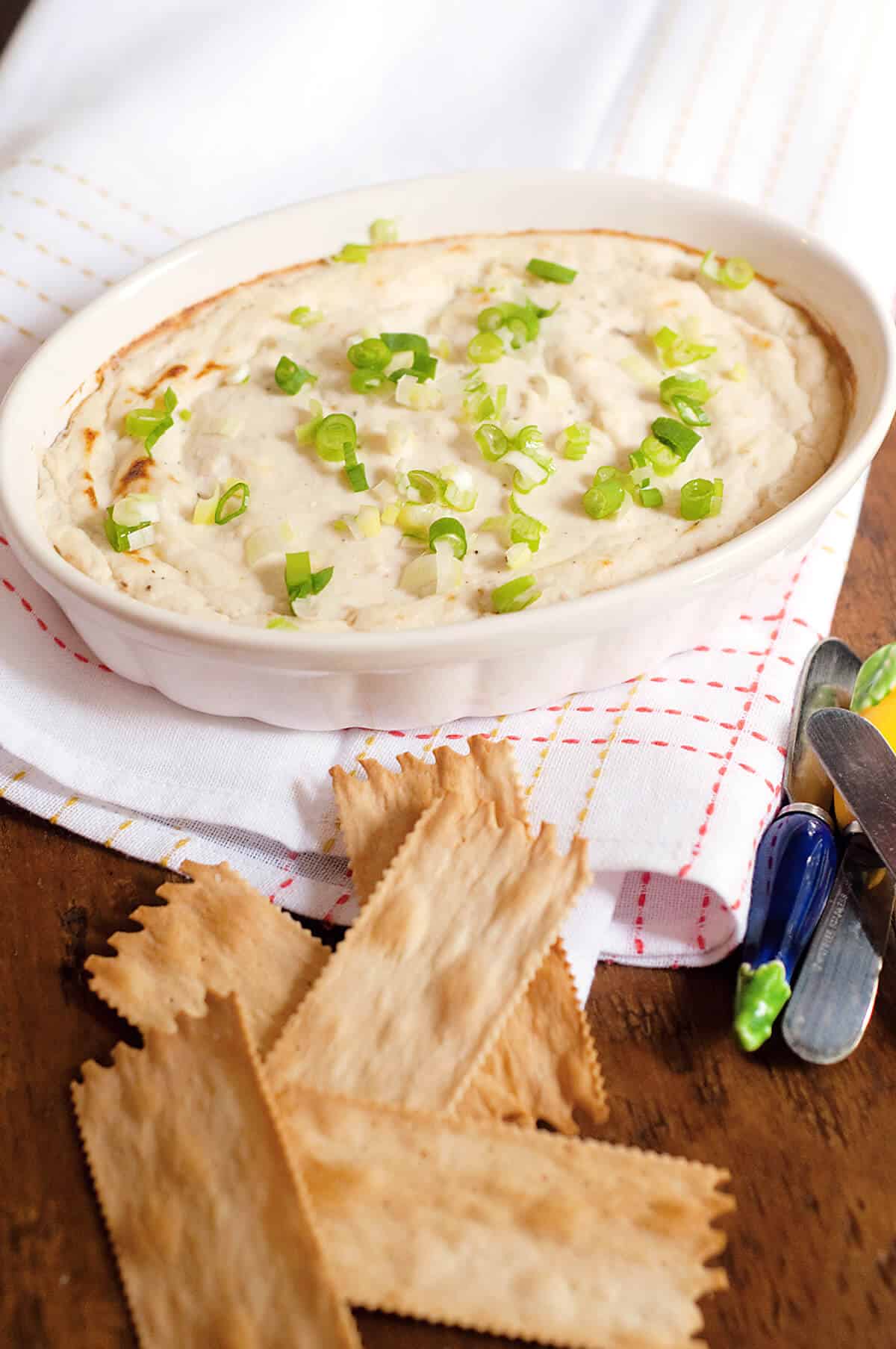 Crab dip in a baking dish with crackers on the side.