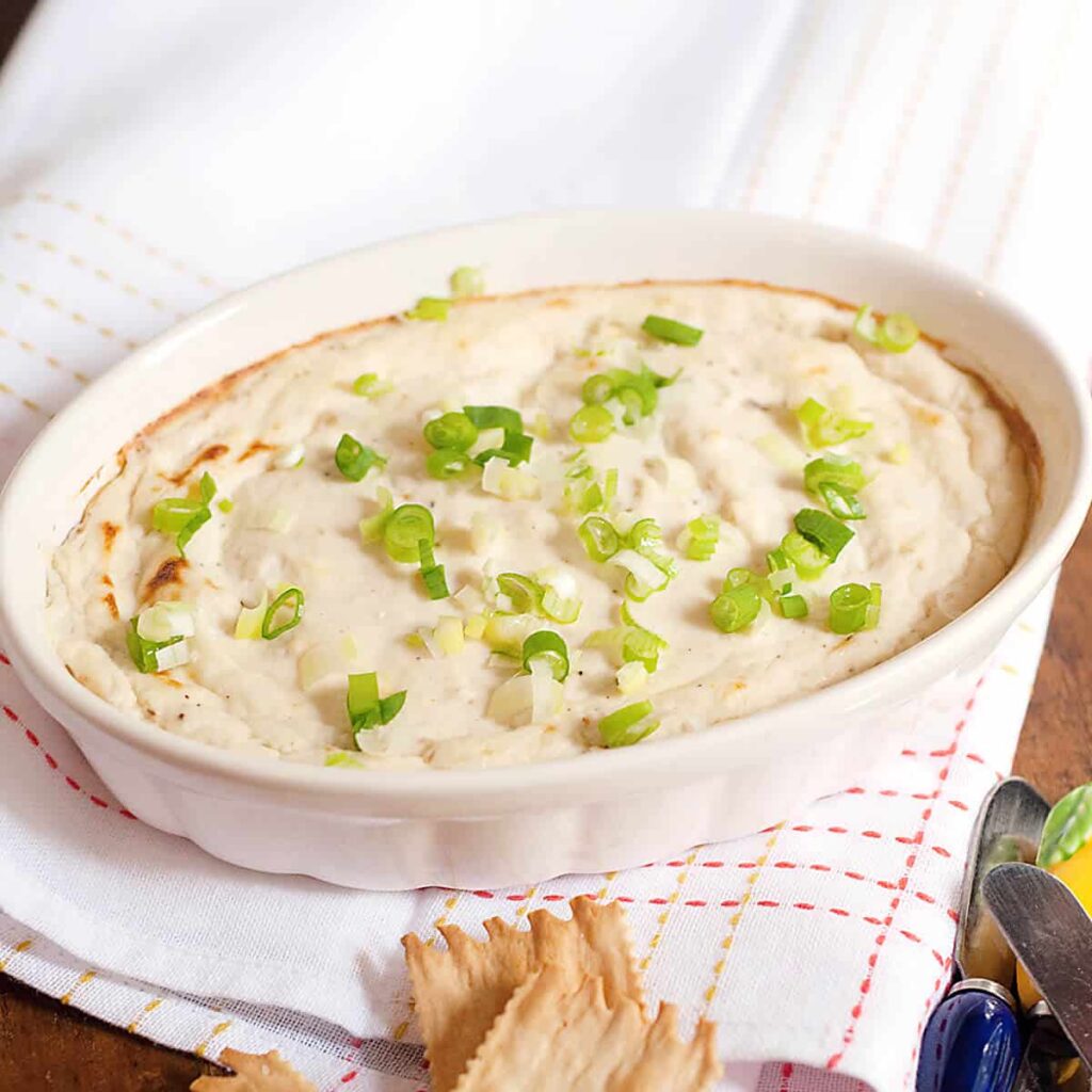 Crab dip in a baking dish with crackers on the side.