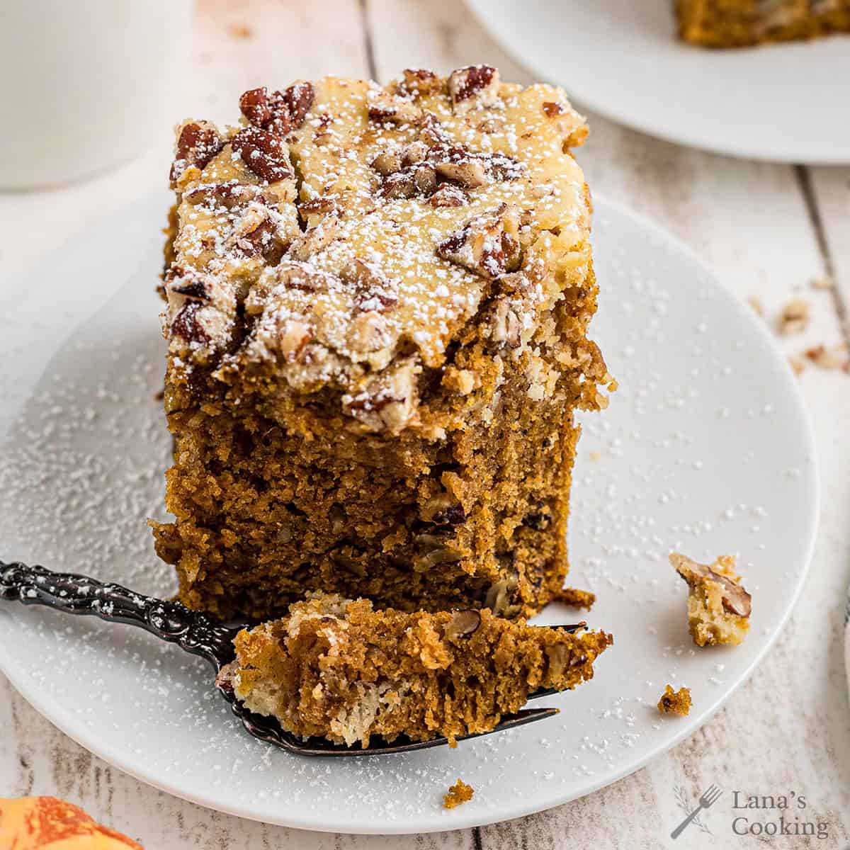 A pumpkin cream cheese brownie on a white serving plate.