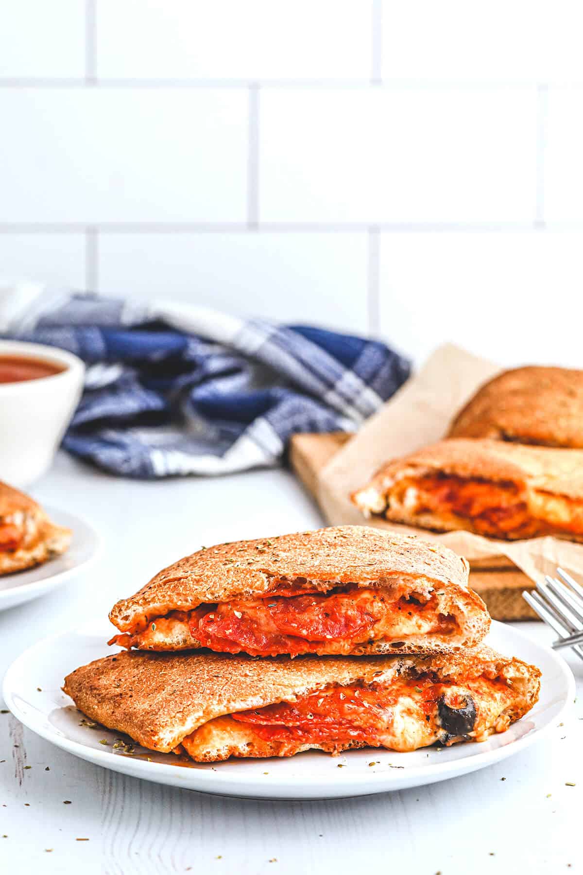 A serving of pepperoni calzone on a white plate.