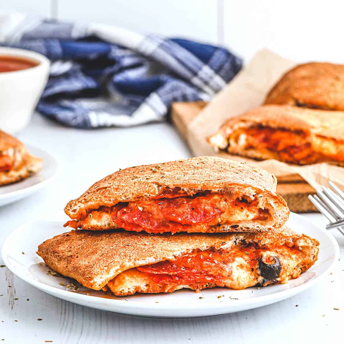 A serving of pepperoni calzone on a white plate.