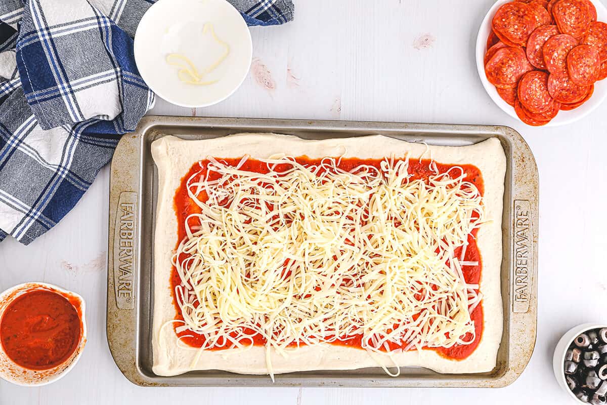 Shredded mozzarella over top of pizza sauce.