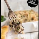 A forkful of Turkey tetrazzini casserole in a white baking pan.