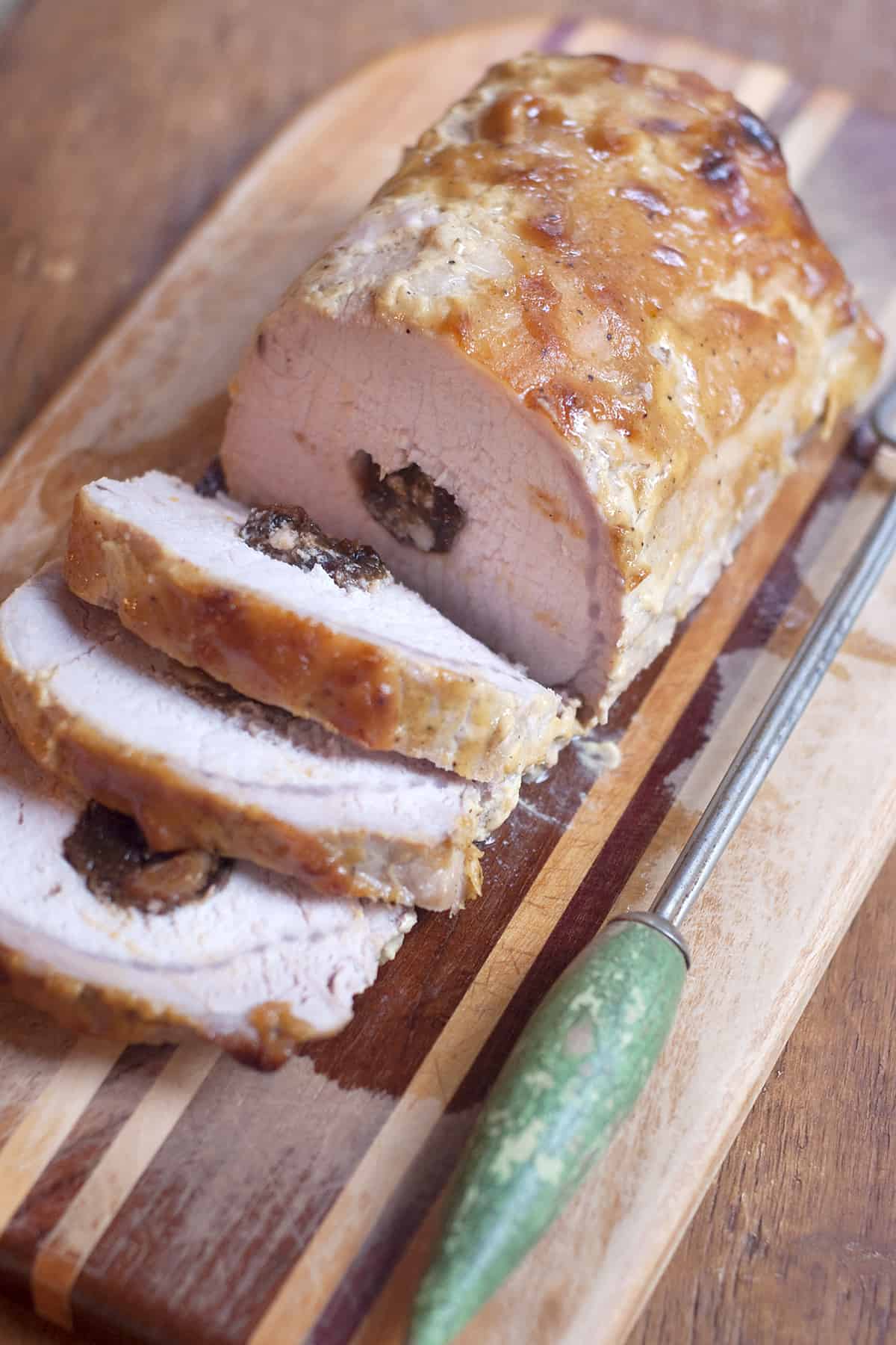 Sliced Apricot and Prune Stuffed Pork Loin on a serving tray.