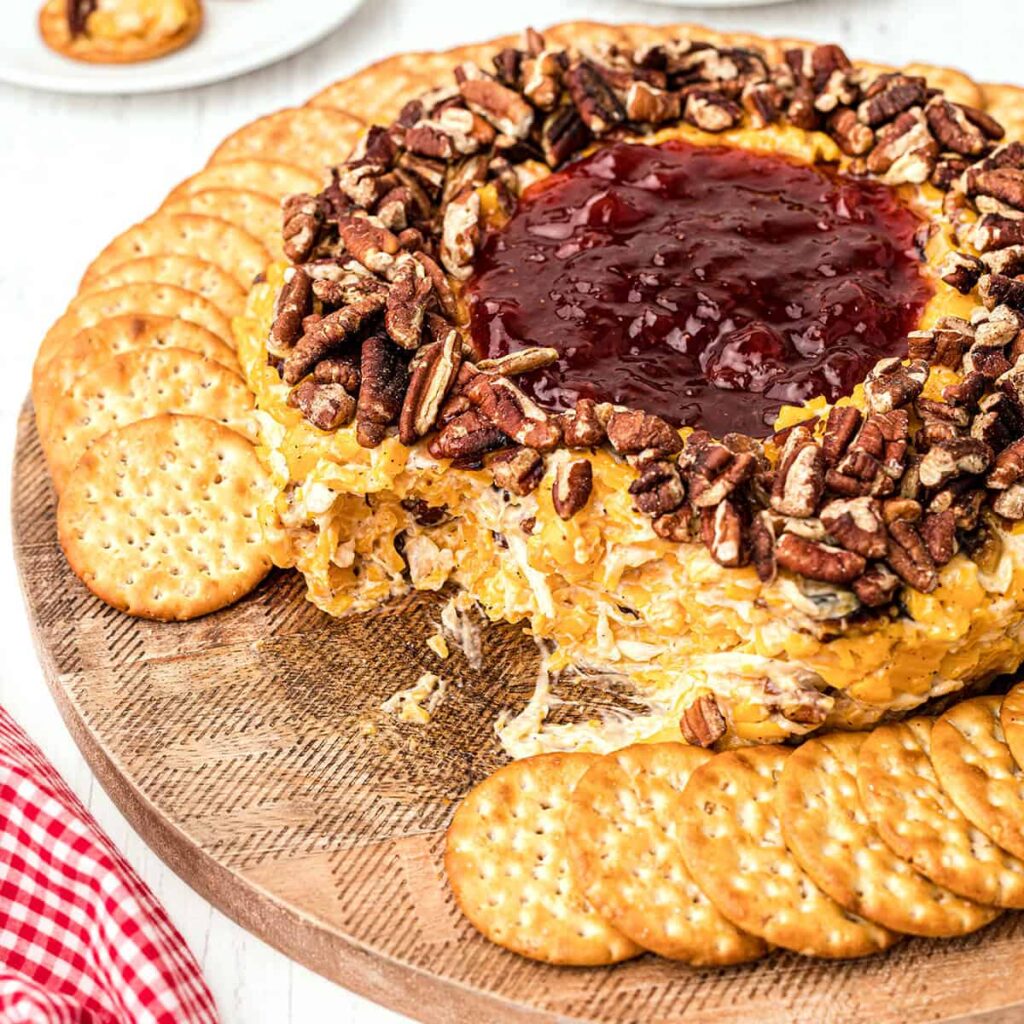 Cheese ring surrounded by crackers on a serving board.