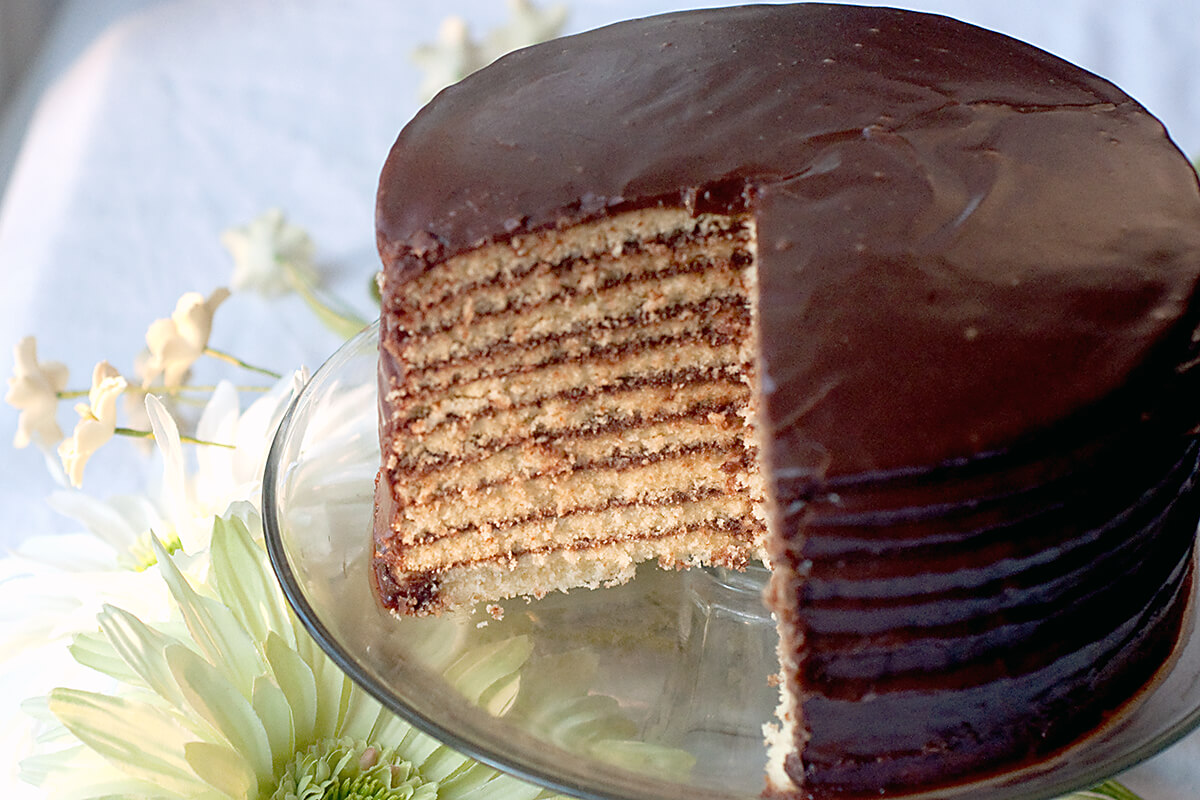 Chocolate little layer cake on a glass cake stand.