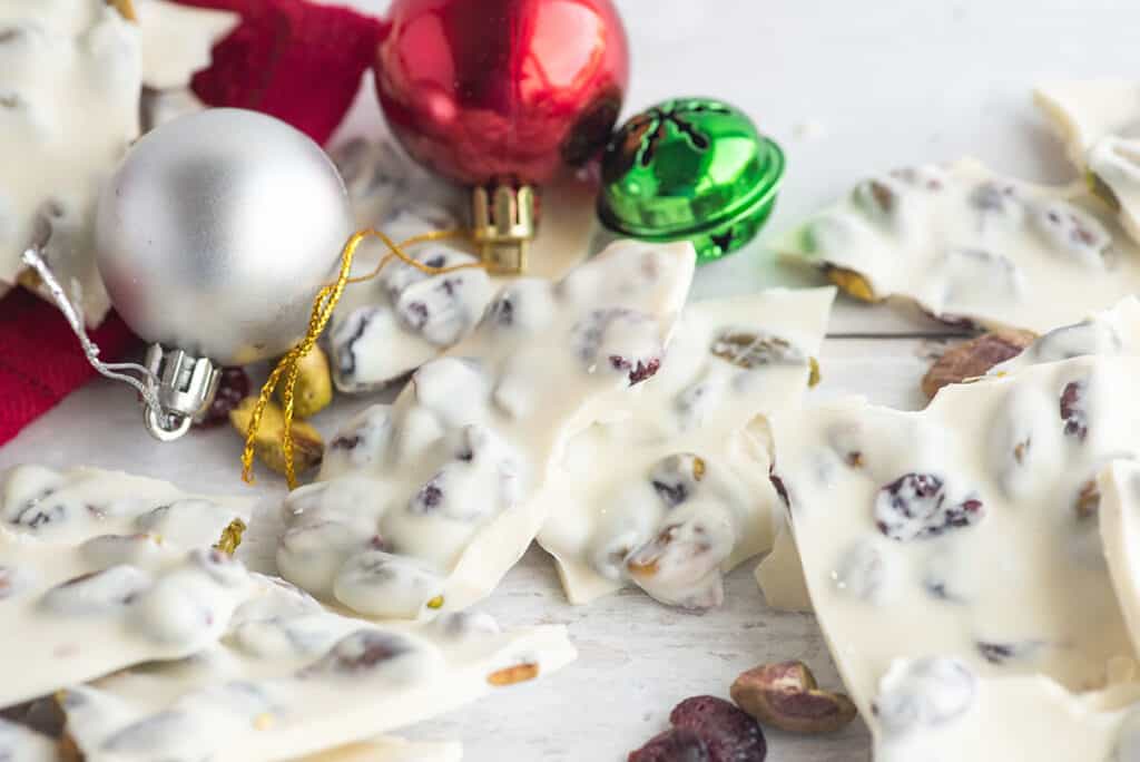 White chocolate bark pieces spread out with Christmas ornaments.