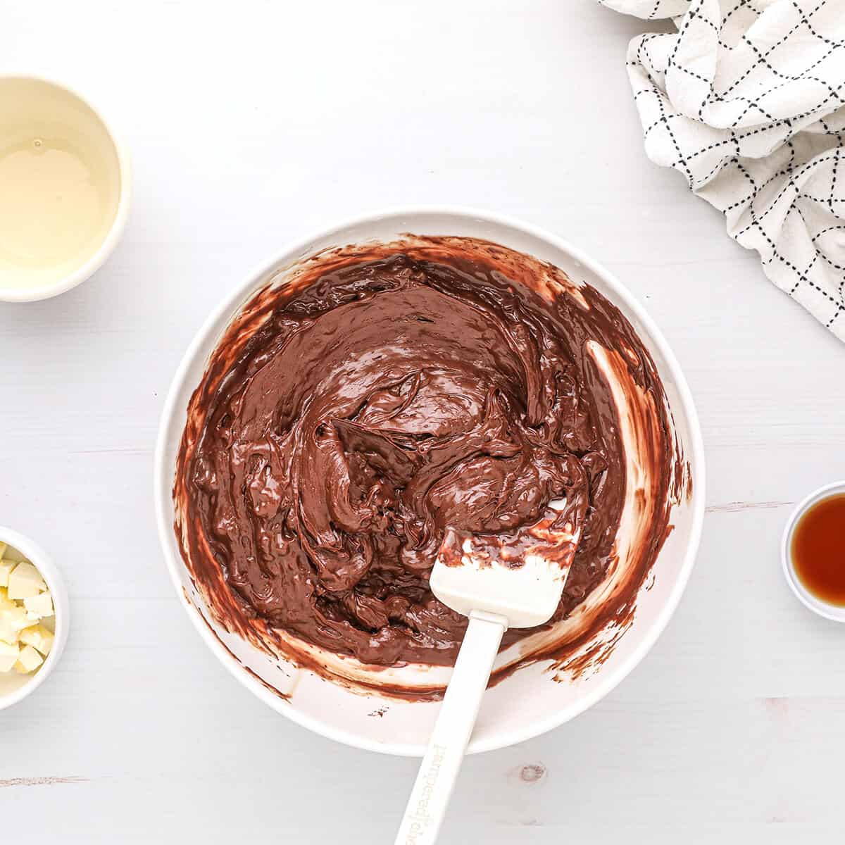 Milk and chocolate stirred together in a bowl.