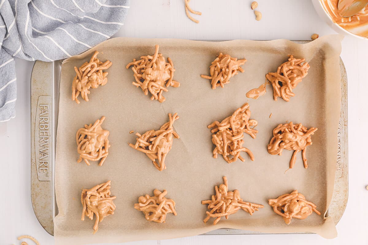 Teaspoonfuls of haystacks candy dropped onto a baking sheet.