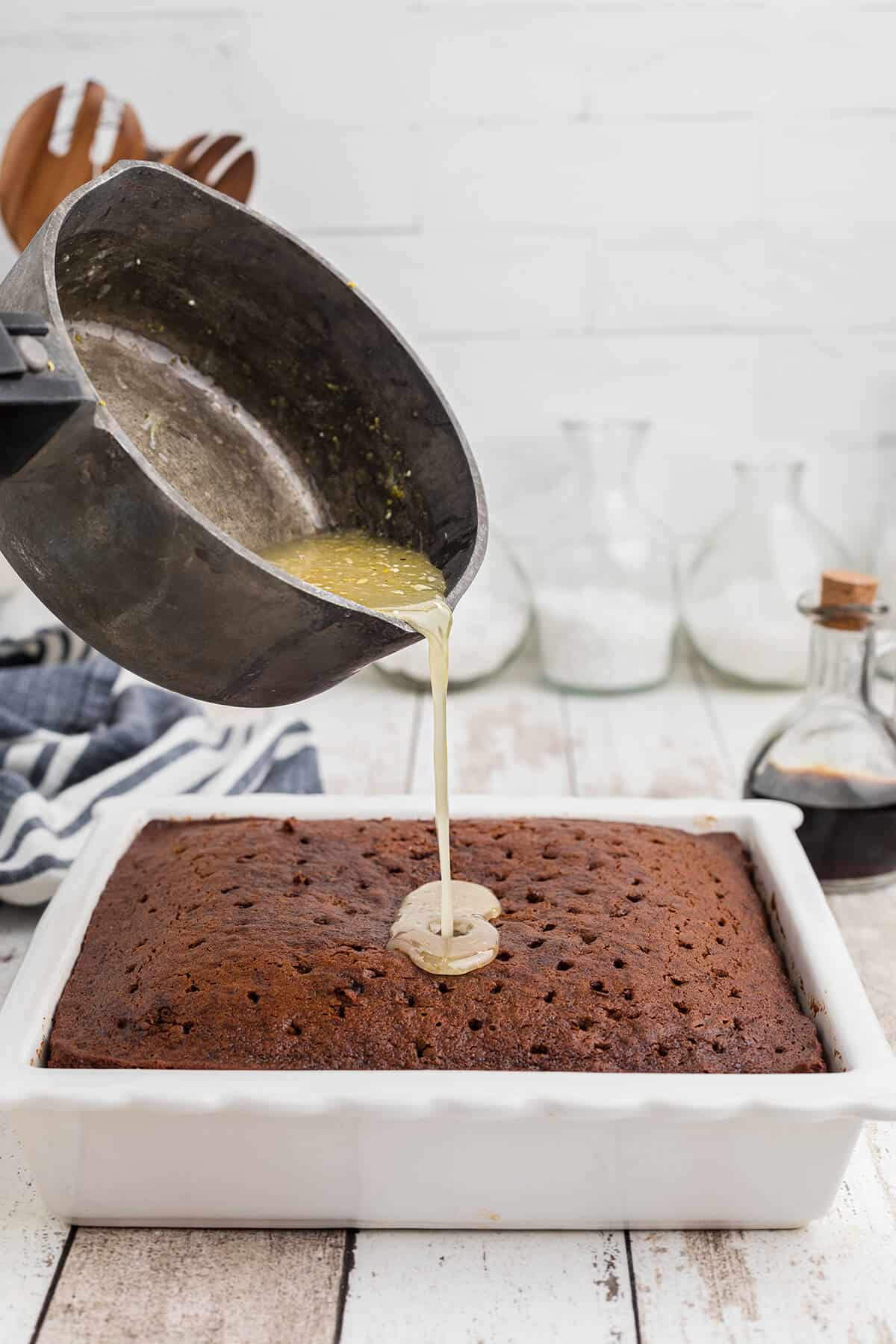 Lemon glaze being poured over warm gingerbread.