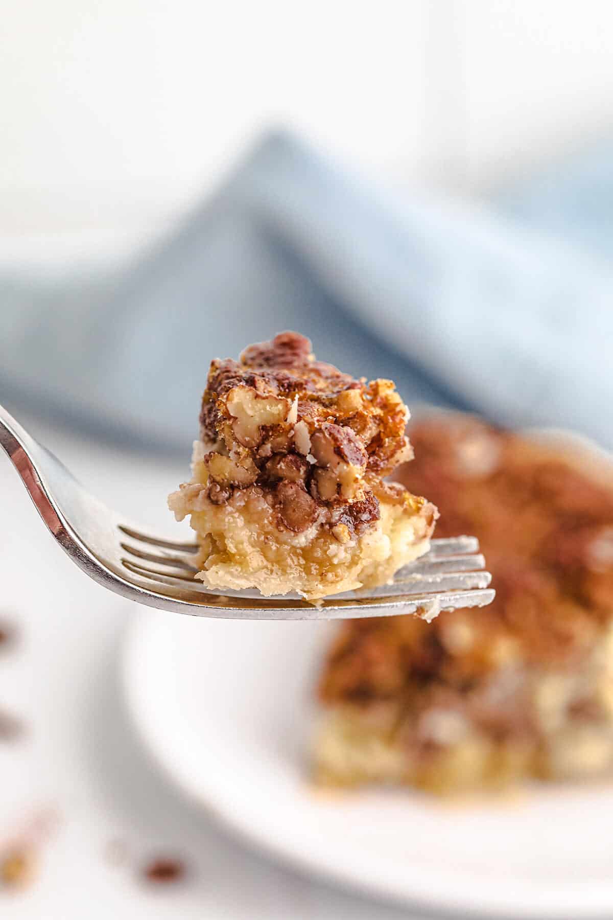 A bite of pecan cheesecake pie on a fork.