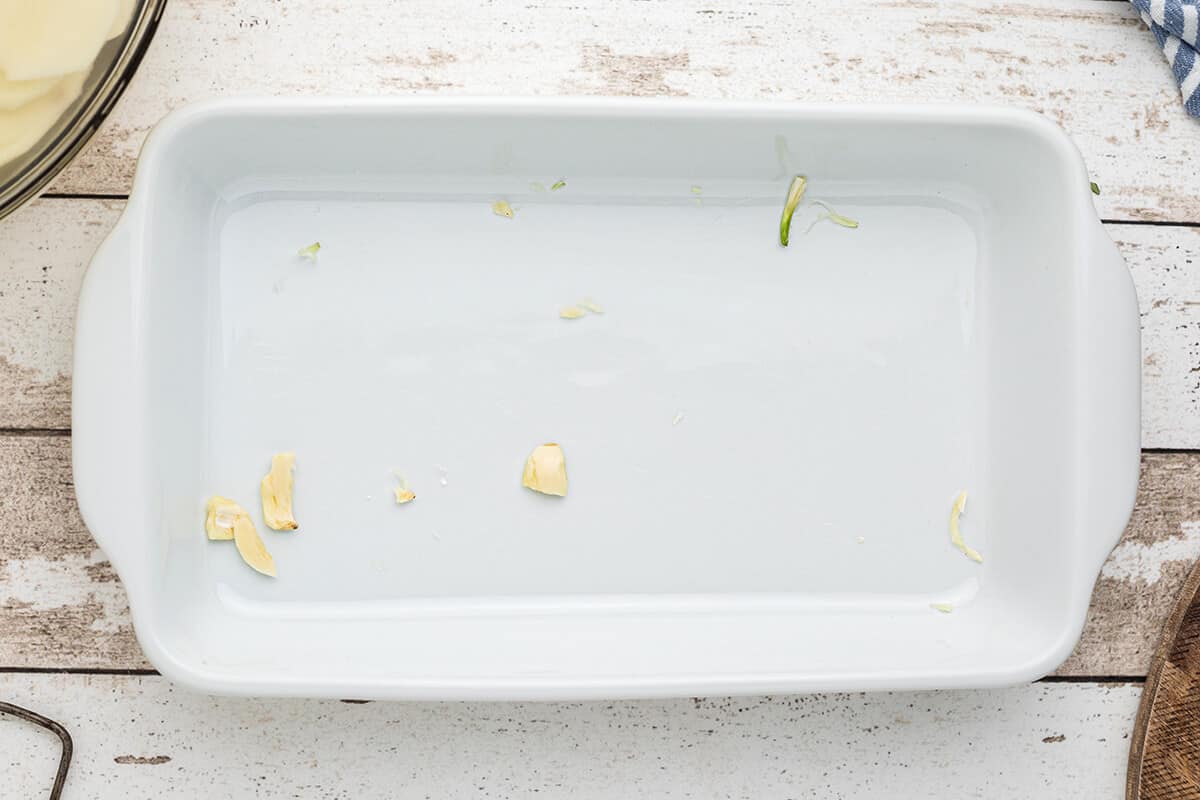 Crushed garlic clove in a baking dish.