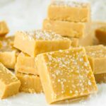 Squares of salted butterscotch fudge on a white background.