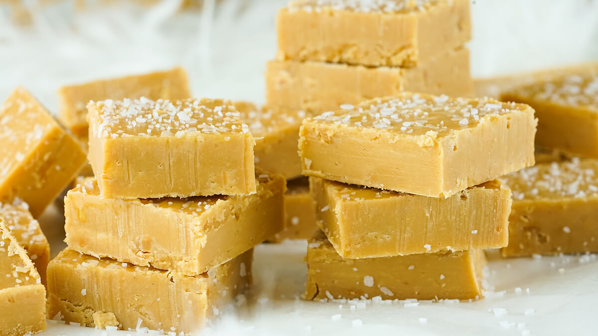 Squares of salted butterscotch fudge on a white background.