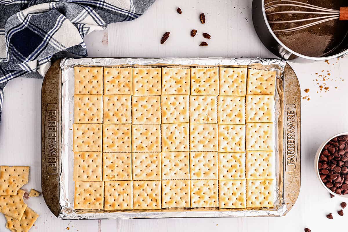 A layer of saltine crackers on a foil-lined baking sheet.