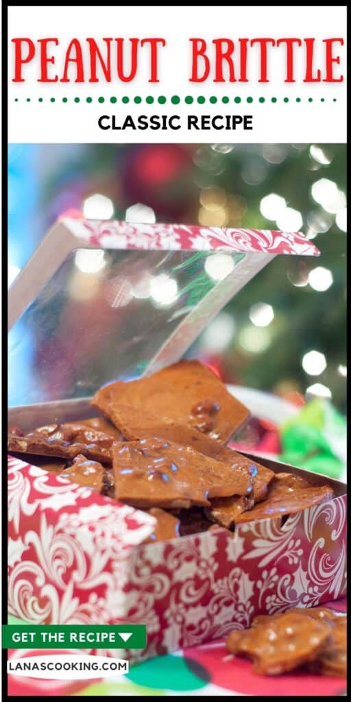 Peanut brittle in a candy gift box with Christmas tree lights in the background.