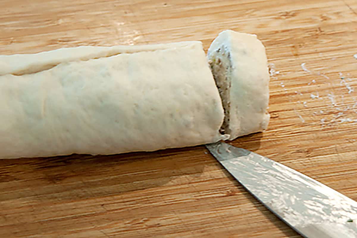 Cutting the rolled dough into pinwheels.