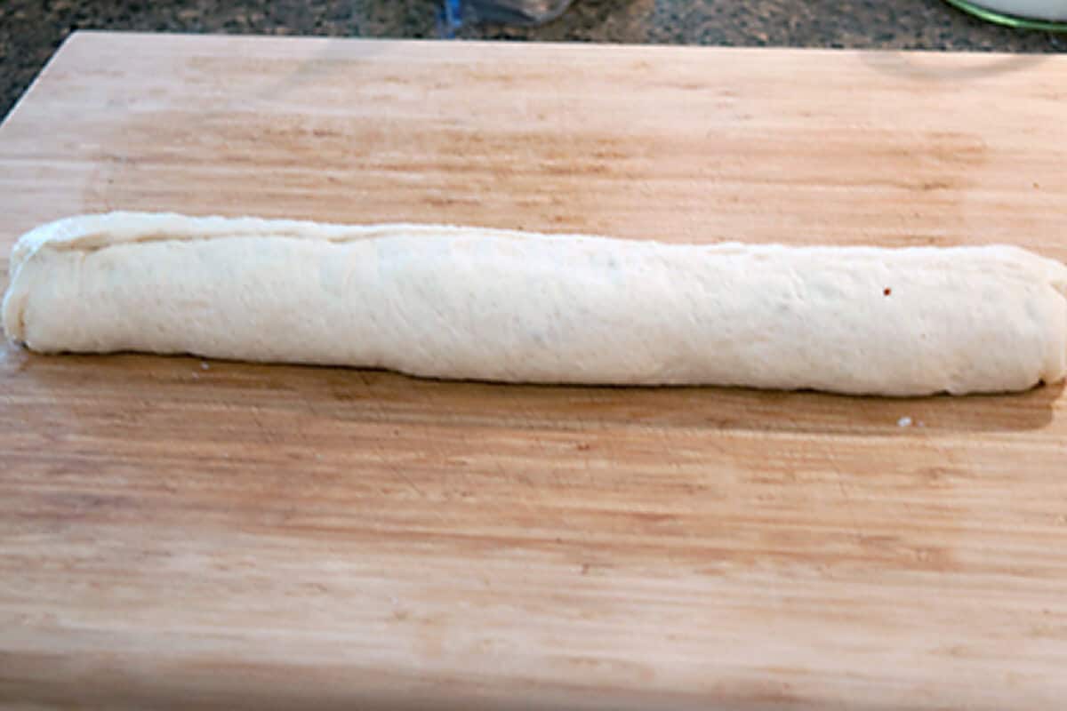 Rolled pizza dough on a board.
