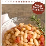 A serving of beans and tomatoes in a clear glass bowl.