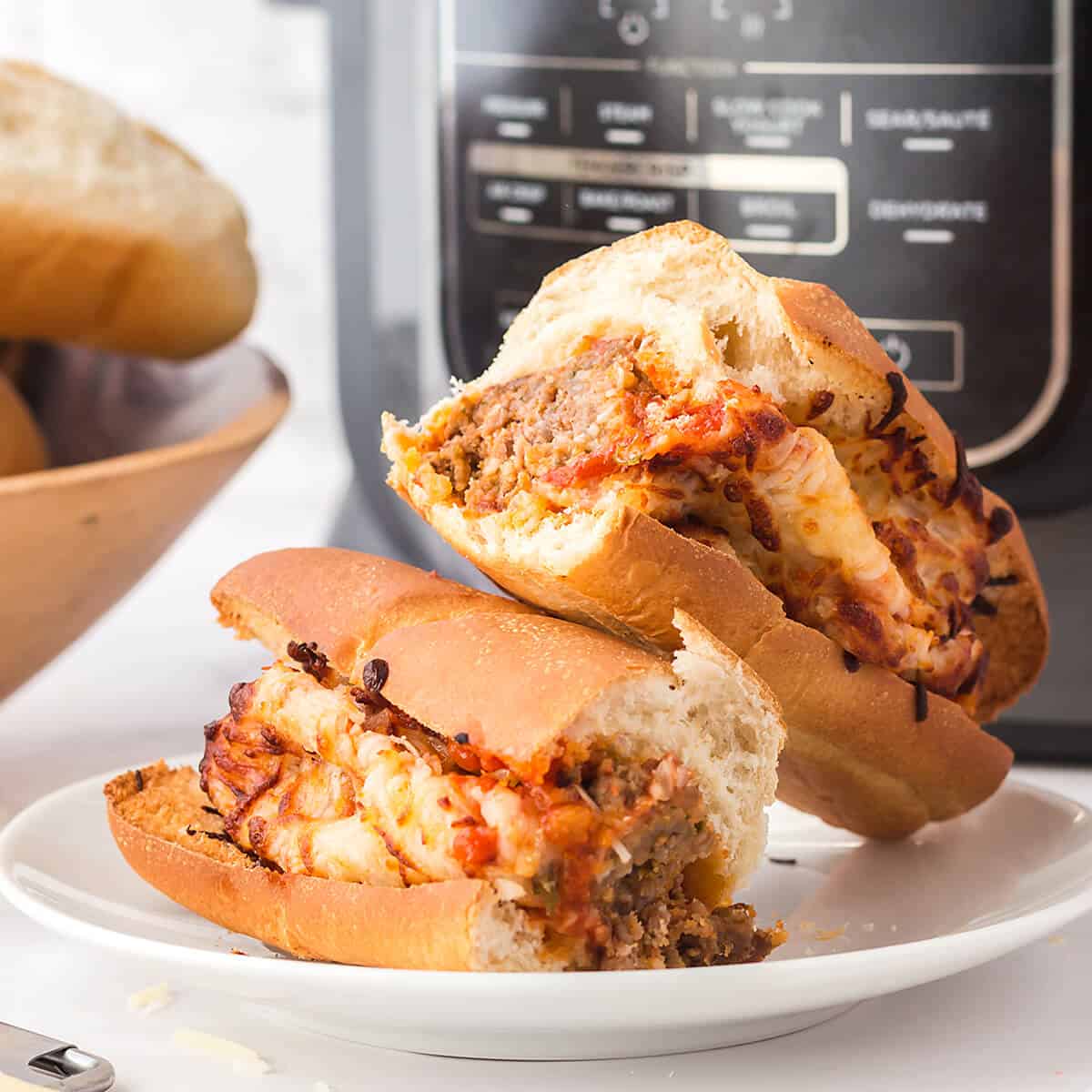 A finished meatball sub split in half on a serving plate.