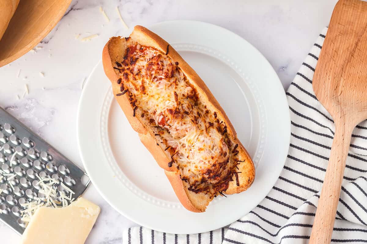 A whole finished meatball sub on a serving plate.